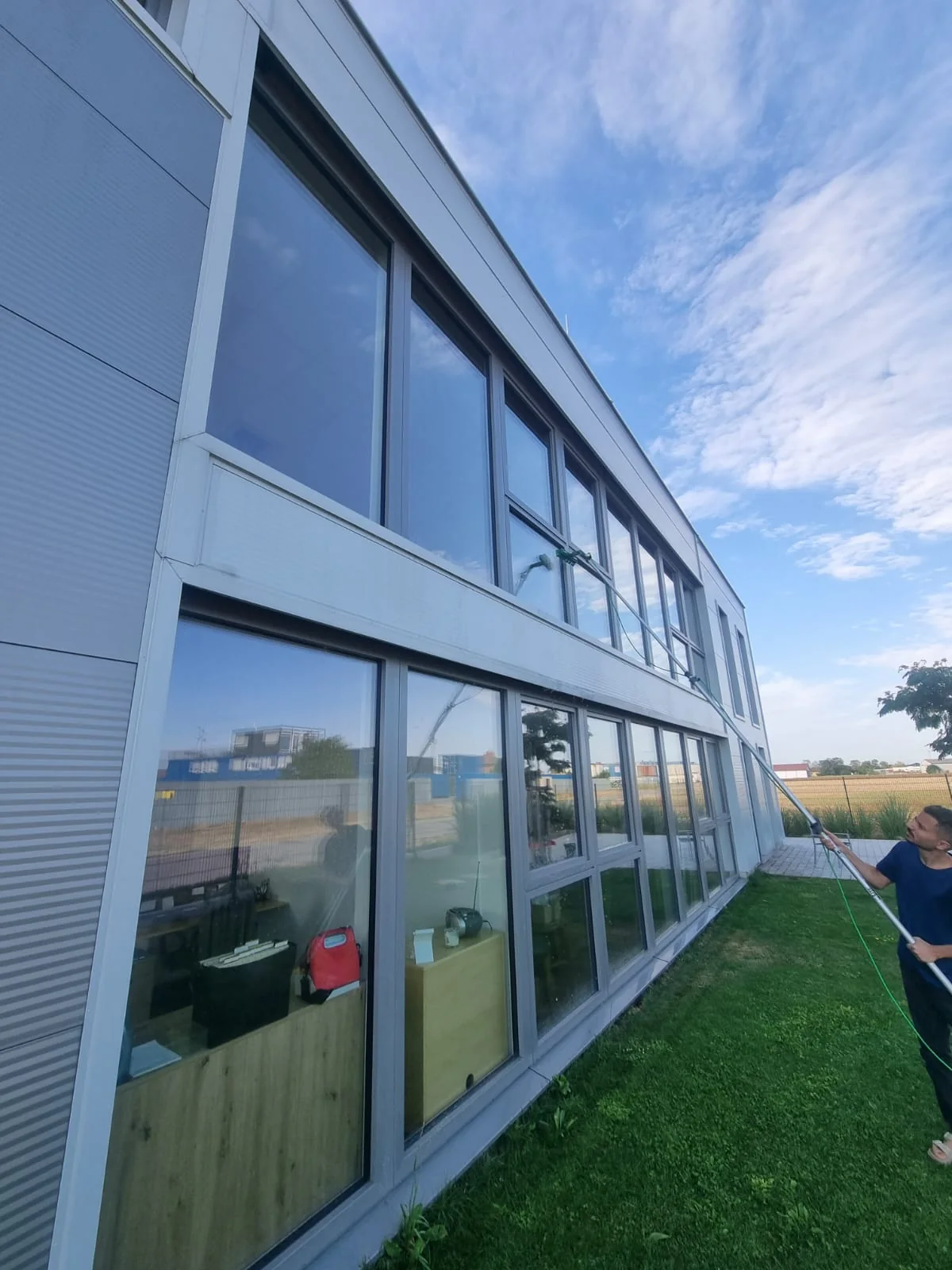 Mitarbeiter bei der Glasfassadenreinigung bei Fuchs Packaging Solutions